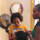 Salon Deguene Chimere, Point E, Dakar applying hair extensions.